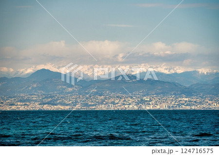 Alps mountains with white snow and clouds, sea in Nice, France Alps mountains with white snow and clouds, sea in Nice, France 124716575