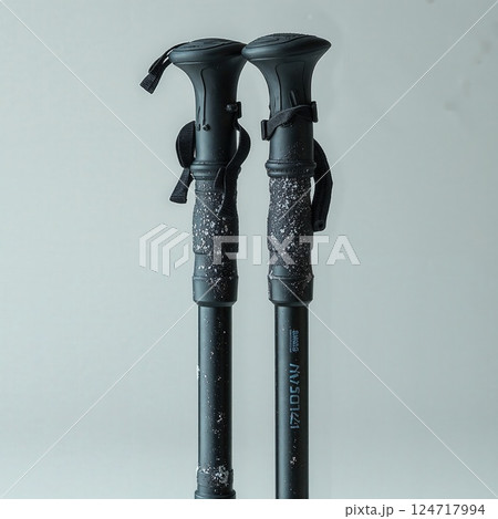 Sleek black trekking poles with snow detail highlighting outdoor adventure and winter exploration 124717994