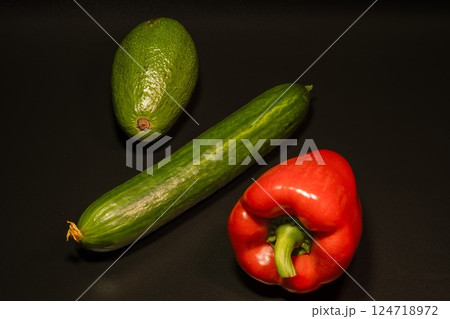 Avocado, cucumber, pepper on a black background Avocado, cucumber, pepper on a black background 124718972
