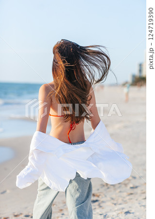Silhouette of the beautiful girl enjoying beautiful sunset on the beach Silhouette of the beautiful girl enjoying beautiful sunset on the beach 124719390