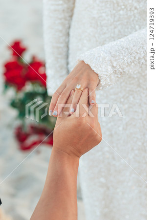 Closeup man putting engagement ring on woman hand on the beach Closeup man putting engagement ring on woman hand on the beach 124719393