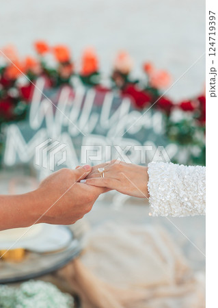 Closeup man putting engagement ring on woman hand on the beach Closeup man putting engagement ring on woman hand on the beach 124719397