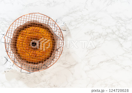 Flat lay. Cooling freshly baked pumpkin bundt cake on the kitchen counter. Flat lay. Cooling freshly baked pumpkin bundt cake on the kitchen counter. 124720028