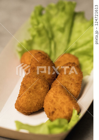 Crispy fried appetizers arranged beautifully on a bed of fresh lettuce in a casual dining setting during a sunny afternoon 124721613