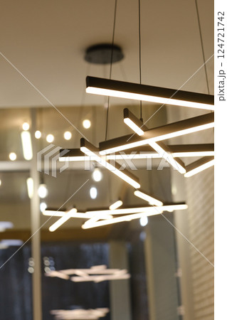 Modern lighting fixtures create a warm and inviting atmosphere in a contemporary interior space during the evening 124721742