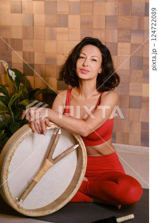 Portrait of an athletic woman with a tambourine in the gym. Kalimeditation class Portrait of an athletic woman with a tambourine in the gym. Kalimeditation class 124722089