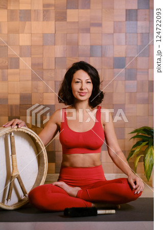 Portrait of an athletic woman with a tambourine in the gym. Kalimeditation class Portrait of an athletic woman with a tambourine in the gym. Kalimeditation class 124722093