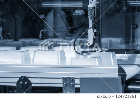 Close up scene material handling process the food container by robotic system from injection machine. 124723261