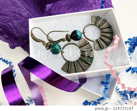 Unique earrings for women on a purple background, promotional photo for an online vintage and handmade jewelry store 124725197