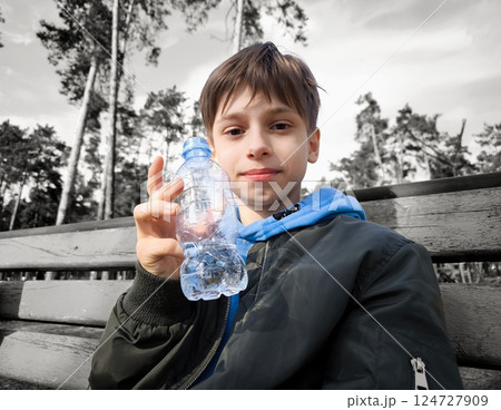 Little boy holding water bottle. Outdoor training. Thirsty. Plastic drink. Happy teenager with a bottle of water. Pretty teenager lifestyle. Happy people. Little boy holding water bottle. Outdoor training. Thirsty. Plastic drink. Happy teenager with a bottle of water. Pretty teenager lifestyle. Happy people. 124727909