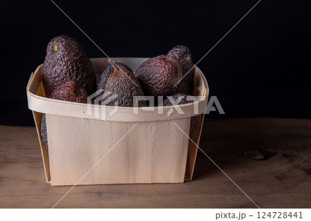 Hass avocados in wooden box. The Hass avocado is a variety of avocado with dark green bumpy skin. 124728441