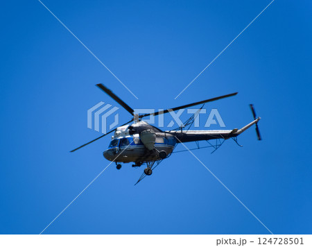 A helicopter of agricultural aviation is flying in the blue sky. A helicopter of agricultural aviation is flying in the blue sky. 124728501