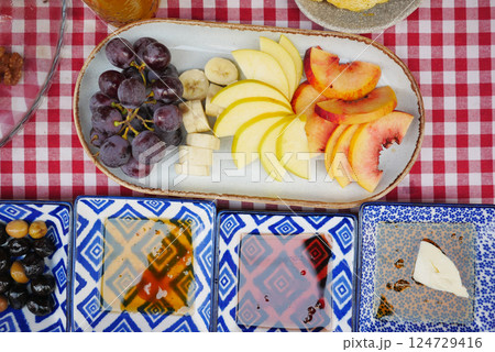 A beautiful assortment of fresh fruits with dips, nicely arranged on a picnic table A beautiful assortment of fresh fruits with dips, nicely arranged on a picnic table 124729416