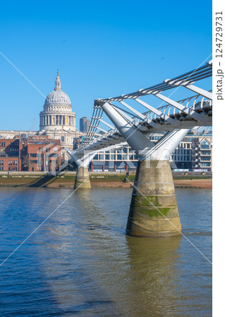 The iconic Millennium Bridge stretches across the River Thames, with St. Paul's Cathedral majestically rising in the background against a clear blue sky. The iconic Millennium Bridge stretches across the River Thames, with St. Paul's Cathedral majestically rising in the background against a clear blue sky. 124729731