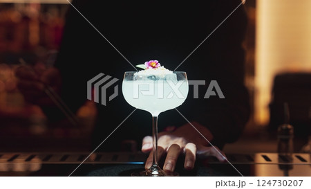 Bartender serving mixed creamy vodka cocktail adding pink flower top. Vinosity. Bartender serving mixed creamy vodka cocktail adding pink flower top. Vinosity. 124730207