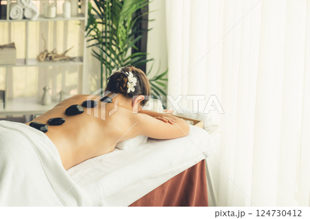 Hot stone massage at spa salon in luxury resort. Quiescent Hot stone massage at spa salon in luxury resort. Quiescent 124730412