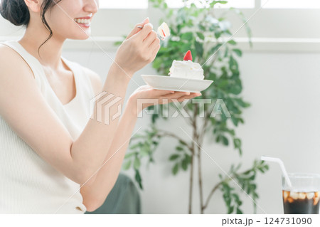 家でおやつ・間食のケーキを食べる女性 124731090