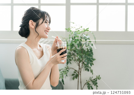 家でおやつ・間食の時間にアイスコーヒーを飲む女性 124731093