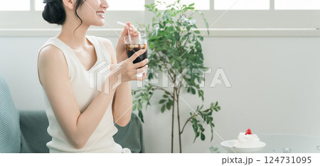 家でおやつ・間食の時間にアイスコーヒーを飲む女性 家でおやつ・間食の時間にアイスコーヒーを飲む女性 124731095