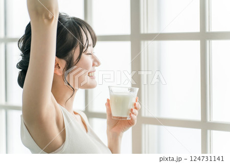 家で朝ミルク・牛乳を飲むアジア人女性 家で朝ミルク・牛乳を飲むアジア人女性 124731141