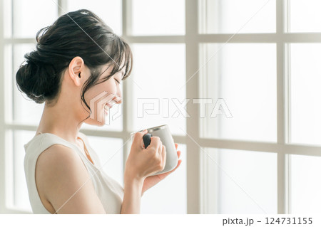 保温マグカップで朝、家でお茶・白湯を飲むリラックスするアジア人女性(温活) 保温マグカップで朝、家でお茶・白湯を飲むリラックスするアジア人女性(温活) 124731155