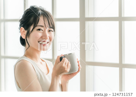 保温マグカップで朝、家でお茶・白湯を飲むリラックスするアジア人女性（温活） 124731157