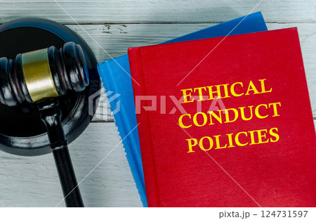 Top view of Ethical Conduct Policies text on red cover book with gavel background. Work policies and procedures. 124731597