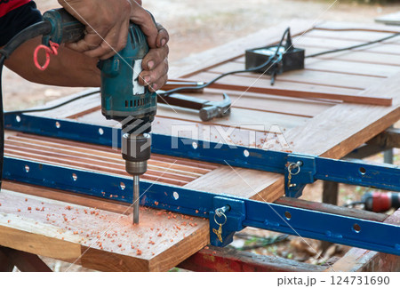Selective focus hand drilling wood, hole in wooden oak board for wooden dowel. carpentry industry. 124731690