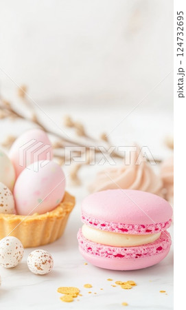 Delicate pastel dessert arrangement featuring lemon tart, pink macaron, and vanilla cupcake with Easter details 124732695