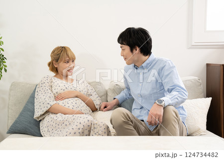 リビングでくつろぐ妊娠中の夫婦 リビングでくつろぐ妊娠中の夫婦 124734482