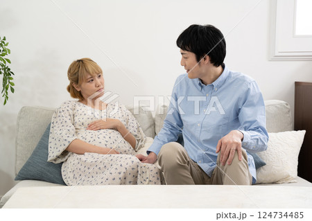 リビングでくつろぐ妊娠中の夫婦 リビングでくつろぐ妊娠中の夫婦 124734485