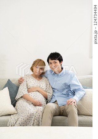 リビングでくつろぐ妊娠中の夫婦 リビングでくつろぐ妊娠中の夫婦 124734494