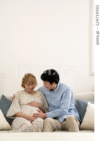 リビングでくつろぐ妊娠中の夫婦 124734501