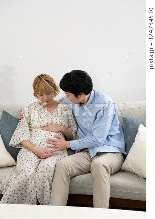 リビングでくつろぐ妊娠中の夫婦 リビングでくつろぐ妊娠中の夫婦 124734510