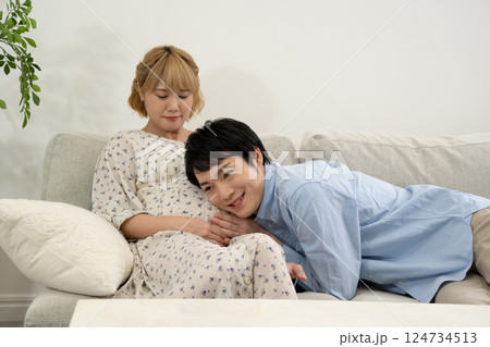 リビングでくつろぐ妊娠中の夫婦 リビングでくつろぐ妊娠中の夫婦 124734513