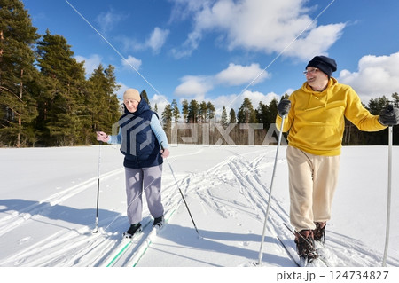 Cheerful Caucasian couple on ski trip in pine forest area. Cheerful Caucasian couple on ski trip in pine forest area. 124734827