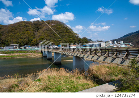 対岸の山に山桜が咲く春の真光寺橋 124735274