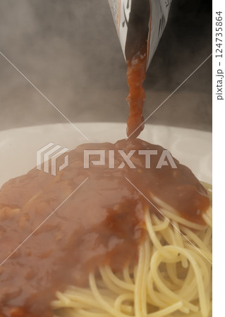 レトルトのパスタソースをパスタにかける レトルトのパスタソースをパスタにかける 124735864