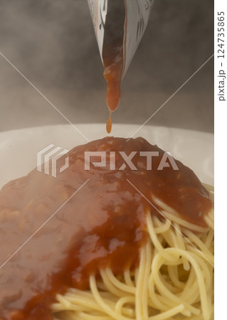 レトルトのパスタソースをパスタにかける 124735865