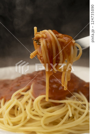レトルトのパスタソースをかけたスパゲティーをフォークで持ち上げる レトルトのパスタソースをかけたスパゲティーをフォークで持ち上げる 124735890