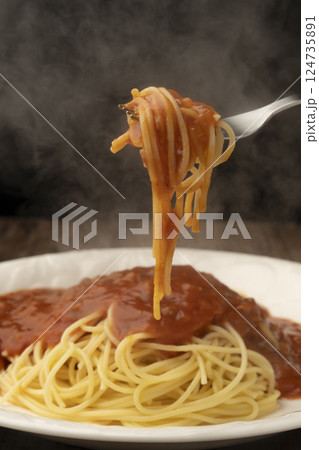 レトルトのパスタソースをかけたスパゲティーをフォークで持ち上げる レトルトのパスタソースをかけたスパゲティーをフォークで持ち上げる 124735891