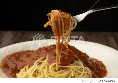 レトルトのパスタソースをかけたスパゲティーをフォークで持ち上げる 124735893