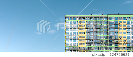 Building with modern facade. Tall high rise apartment with clear blue sky, sunny metropolitan 124736621