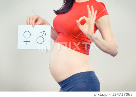 Woman in pregnant holding card with female and masculine symbol 124737065