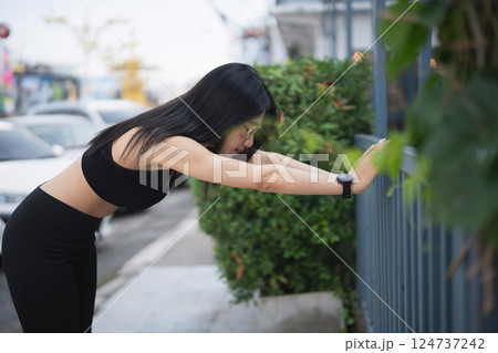 Young Woman Stretching in Urban Environment for Fitness and Wellness, Focused on Health and Exercise with Nature Background in Outdoor Setting Young Woman Stretching in Urban Environment for Fitness and Wellness, Focused on Health and Exercise with Nature Background in Outdoor Setting 124737242