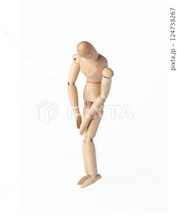 A Wooden dummy with hands down, conveying sadness. A Poseable figure and Articulated mannequin capture a moment of despair, perfect for artists and creating expressive, emotional sketches. 124738267
