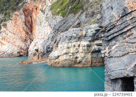 View of cliffs and turquoise sea in Porto Venere, Italy. Entrance to cave. Panorama and nature. Sunny day and tranquility. View of cliffs and turquoise sea in Porto Venere, Italy. Entrance to cave. Panorama and nature. Sunny day and tranquility. 124739401