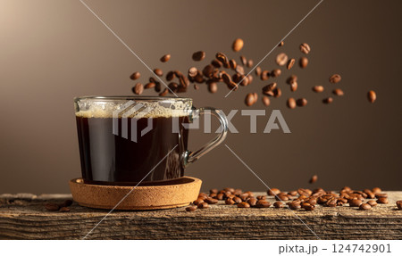Black coffee in glass cup on an old wooden board. Black coffee in glass cup on an old wooden board. 124742901