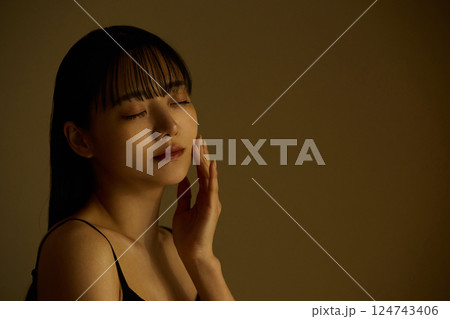 暖色トーンで撮影をした若い女性のスキンケアイメージ 124743406