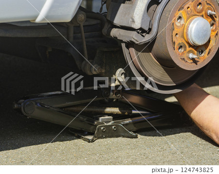 Car in service repairing. Detail of wheel assembly on automobile 124743825